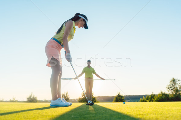 Fit woman exercising hitting technique during golf class with an Stock photo © Kzenon