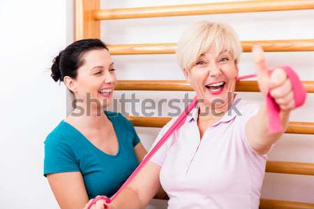 Physio doing shoulder exercises with senior woman Stock photo © Kzenon