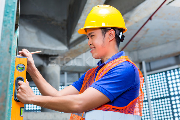 Builder or worker controlling wall on construction site Stock photo © Kzenon