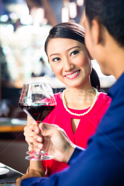 Asian couple with wine in Restaurant Stock photo © Kzenon