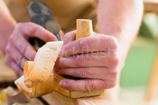 Carpenter with wood planer and workpiece in carpentry Stock photo © Kzenon
