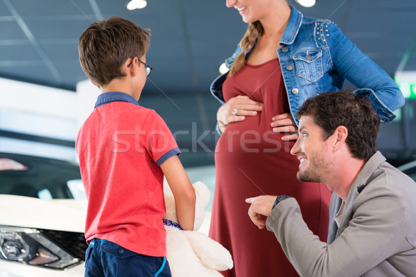 Family with pregnant mom looking for larger car at dealership Stock photo © Kzenon