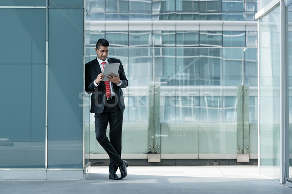 Indian businessman using a tablet PC indoors Stock photo © Kzenon