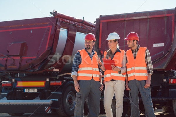 Truck drivers and dispatcher in front of lorries in freight forwarding company Stock photo © Kzenon