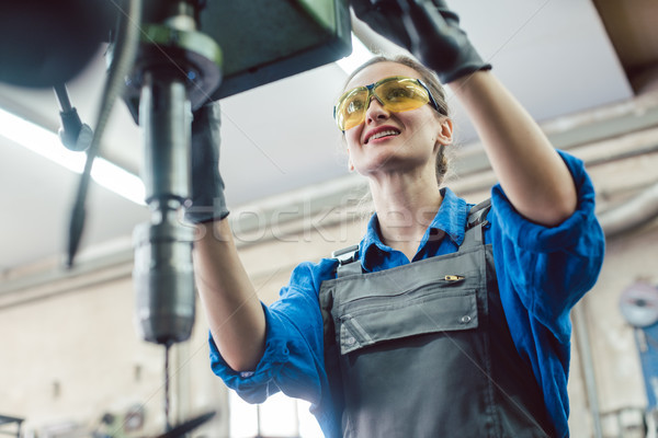 Woman worker in metal workshop using pedestal drill Stock photo © Kzenon