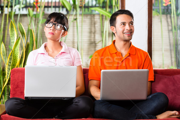 Stock photo: Asian couple on the couch with a laptop