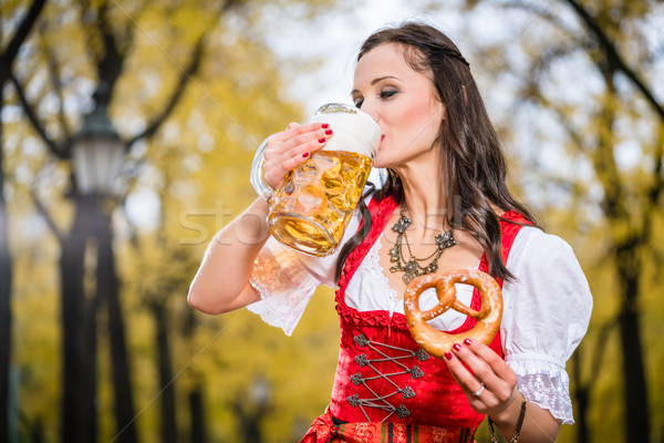 Girl in traditional bavarian Tracht drinking beer out of huge mu Stock photo © Kzenon
