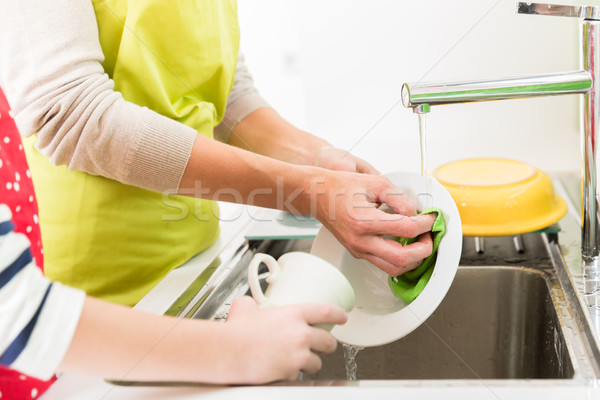 Mom washing-up the crockery, son helping Stock photo © Kzenon