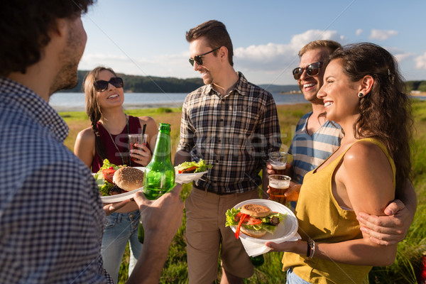 Young people on barbecue party, burger and beer Stock photo © Kzenon