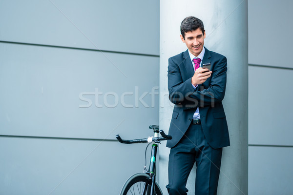 Cheerful young man communicating on mobile phone while waiting o Stock photo © Kzenon