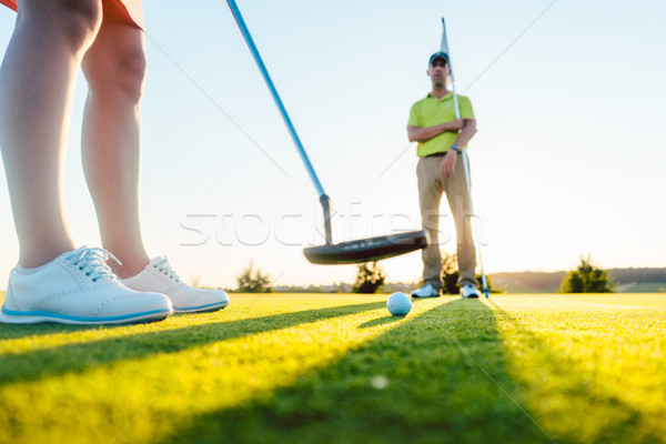 Golf ball in selective focus under the putter club of a female player Stock photo © Kzenon