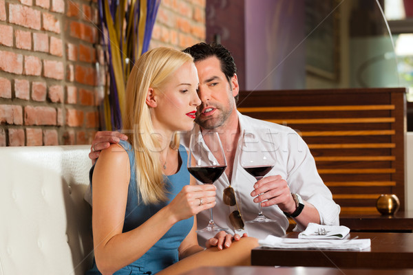 Attractive couple drinking red wine in restaurant or bar Stock photo © Kzenon