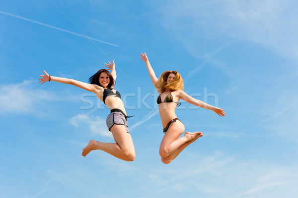 Stock photo: Two happy women jumping high with fun