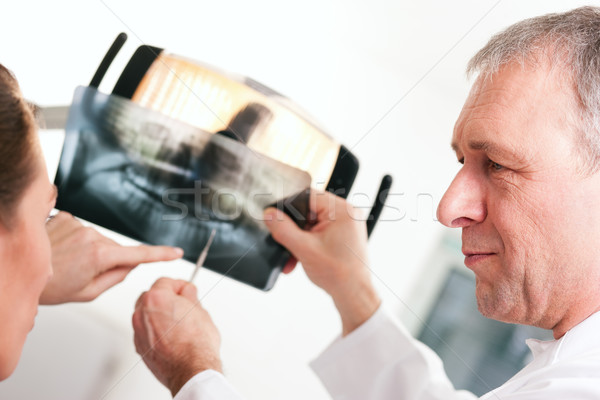 Dentist explaining x-ray to patient Stock photo © Kzenon