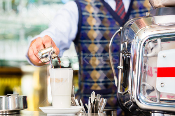 Barista in cafe pouring espresso shot in latte macchiato Stock photo © Kzenon