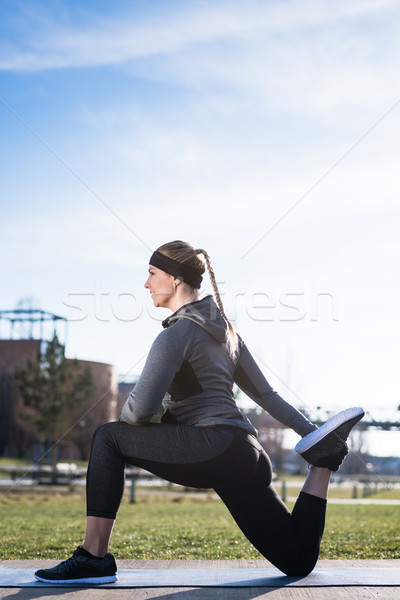 Young woman stretching her quadriceps muscles by grabbing her an Stock photo © Kzenon