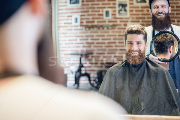 Jonge man glimlachend naar nieuwe modieus kapsel Stockfoto © Kzenon