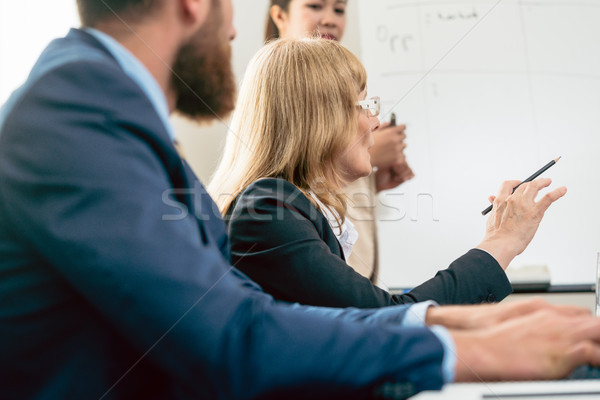 Middle-aged business woman presenting her opinion during a meeting Stock photo © Kzenon