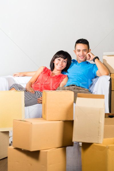 Asian couple having break while moving in Stock photo © Kzenon