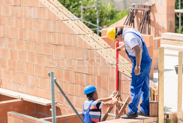 Two worker controlling construction or building site walls Stock photo © Kzenon