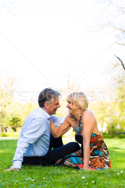 Senior couple during spring on a meadow in the city Stock photo © Kzenon
