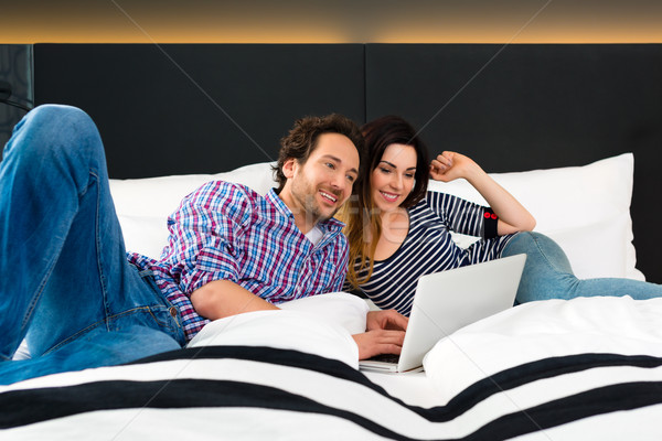 Young couple in Hotel in bed with wifi and computer Stock photo © Kzenon