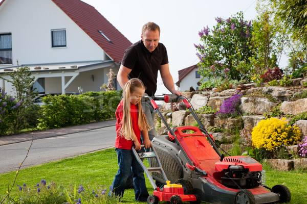 Father and daughter mowing lawn together Stock photo © Kzenon