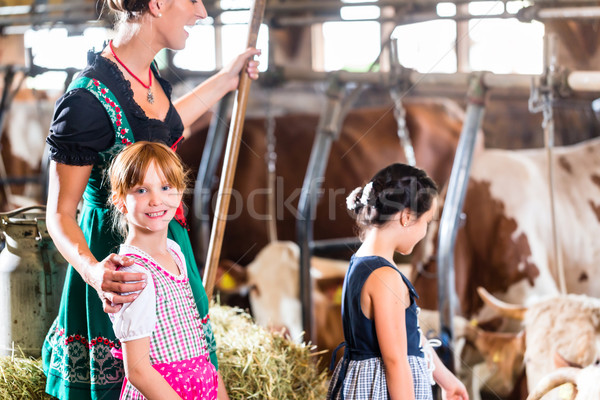 Bavarian mother showing children cows in cowhouse Stock photo © Kzenon