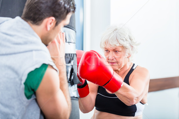 Senior woman with trainer in boxing sparring Stock photo © Kzenon