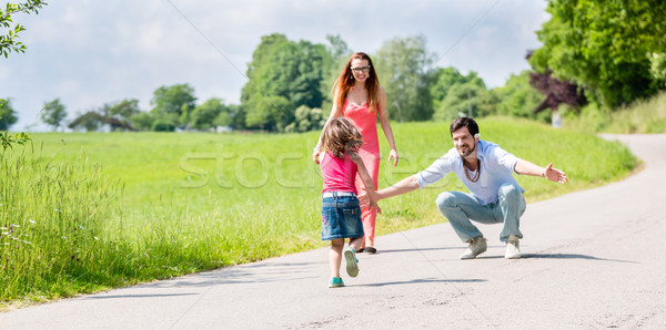 Stock photo: Mom, dad and daughter having walk on path