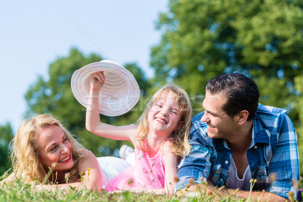 Girl with Mum and Dad, swaying her hat Stock photo © Kzenon