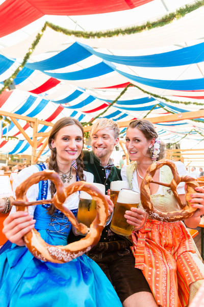 Friends with giant pretzels in Bavarian beer tent Stock photo © Kzenon