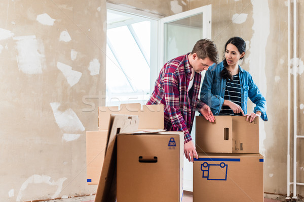 Young couple opening boxes during renovation of new home after m Stock photo © Kzenon