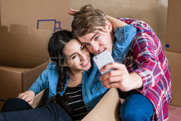 Stock photo: Happy young man and woman making a selfie after moving in together