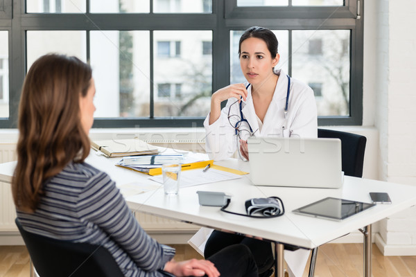 Dedicated doctor listening to her patient during a private consultation Stock photo © Kzenon
