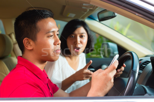 Stock photo: Asian man texting while driving