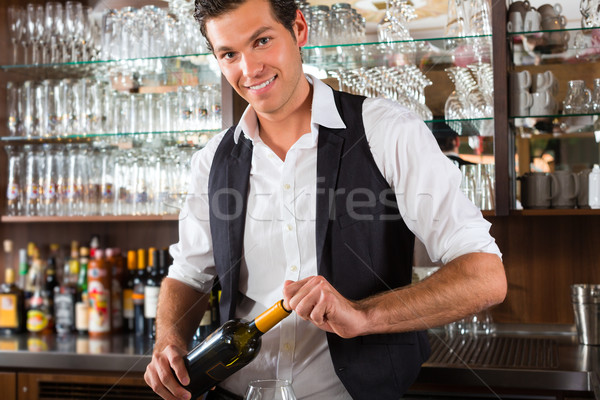 Barman standing behind bar with wine Stock photo © Kzenon