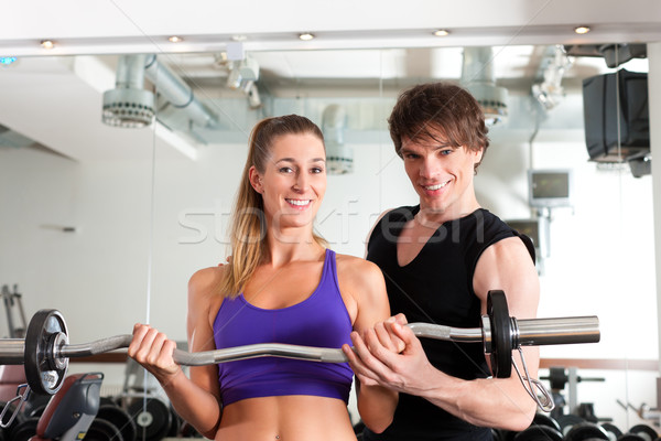 Sport - couple is exercising with barbell in gym Stock photo © Kzenon