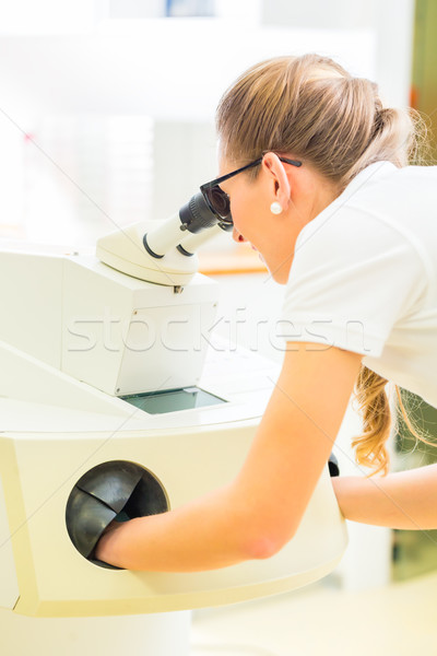 Stock photo: Orthodontist  working with microscope and grinder