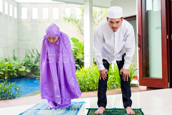 Asian Muslim couple, man and woman, praying at home Stock photo © Kzenon