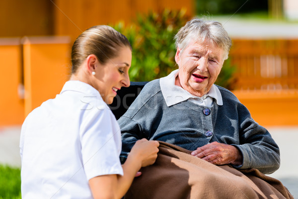 Stockfoto: Verpleegkundige · holding · handen · senior · vrouw · rolstoel · vergadering