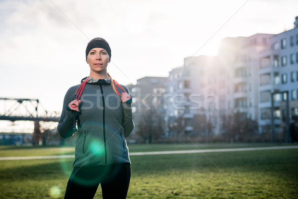 Determined young woman daydreaming while holding a skipping rope Stock photo © Kzenon