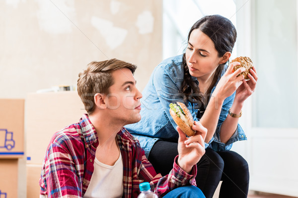 Young couple looking tired while eating a sandwich during break  Stock photo © Kzenon