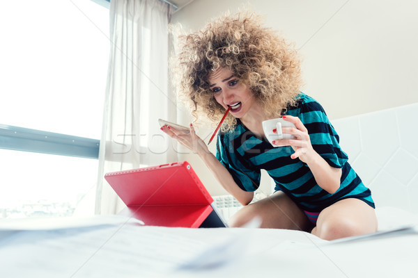Stock photo: Woman student on her bed learning for exam in panic
