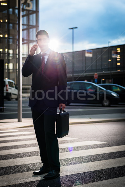 Business man using phone in evening outdoors Stock photo © Kzenon