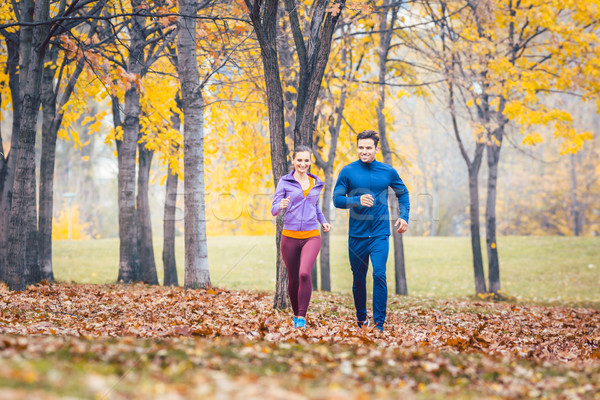 Man and woman running as fitness sport in an autumn park Stock photo © Kzenon