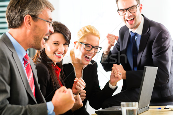 Stock photo: Business people looking at laptop with success