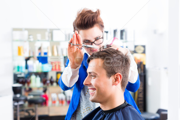 Hairdresser cutting man hair in barbershop Stock photo © Kzenon