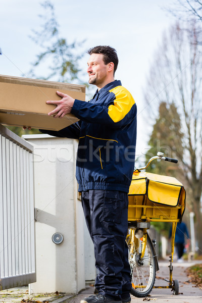 Postman delivering packet wrapped as present Stock photo © Kzenon