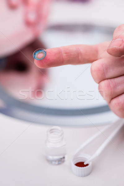 Saleswoman in optician shop showing contact lens Stock photo © Kzenon